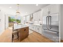 Open concept kitchen with stainless appliances, island with seating, and access to outdoor deck for entertaining and relaxing at 158 Mattoon St, Charlotte, NC 28216