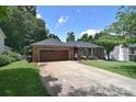 Brick home featuring an attached two-car garage, neat landscaping, and a welcoming driveway at 16433 Grapperhall Dr, Huntersville, NC 28078
