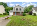 Welcoming two-story home with a gray exterior, brick details, a green lawn, and a practical single-car garage at 2903 Rockingham Sw Ct, Concord, NC 28025