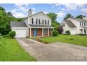 Inviting two-story home with a brick facade, gray siding, a well-kept lawn, and a convenient single-car garage at 2903 Rockingham Sw Ct, Concord, NC 28025