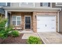 Inviting front porch featuring a brick facade, rocking chairs, and a one car garage at 348 Zocalo Dr, Gastonia, NC 28056