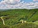 A scenic aerial view reveals a quaint cabin nestled amongst rolling hills covered in dense forest at 362 Sandburg Rd, Union Grove, NC 28689