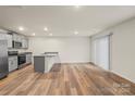 Bright open-concept living space featuring hardwood floors, sliding glass door, and kitchen bar at 4116 Lurelin Ln, Charlotte, NC 28262