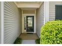 Covered entryway showcasing a modern glass front door, lush landscaping, and neutral siding at 43041 Mimosa Ct, Fort Mill, SC 29707