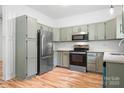 Bright kitchen featuring gray cabinets, stainless steel appliances, and hardwood floors at 4719 Sahalee Ln, Charlotte, NC 28216