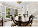 Elegant dining area with a large window featuring plantation shutters, a round table, and a decorative chandelier at 4846 Deer Cross Trl, Charlotte, NC 28269
