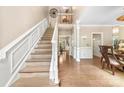 Bright foyer with hardwood floors and staircase featuring white trim, leading to the dining and living areas at 4846 Deer Cross Trl, Charlotte, NC 28269