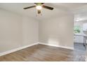Bright living room featuring modern wood flooring, ceiling fan, and access to kitchen at 5715 Coulee Pl, Charlotte, NC 28217