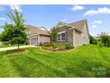 Well-maintained home with stone accents, lush green lawn, and mature landscaping on a sunny day at 7016 Bareland Rd, Fort Mill, SC 29707