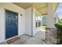 Inviting front porch with stone pillars, a blue front door, and a 'Hello' welcome mat at 7166 Dove Field Ln, Fort Mill, SC 29707