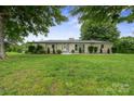 Well-maintained one-story home with a lush green lawn, mature shade trees, and tasteful landscaping at 806 N Central Ave, Locust, NC 28097