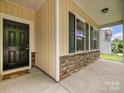 Covered front porch featuring a black front door and stone accents at 9027 Gray Willow Rd, Charlotte, NC 28227