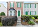 Inviting brick townhome with green door and well-kept front garden at 9775 Mallard Glen Dr, Charlotte, NC 28262
