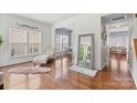 Sunlit living room with hardwood floors, neutral walls, and a view into the dining area at 9775 Mallard Glen Dr, Charlotte, NC 28262