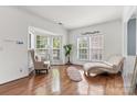 Bright living room with hardwood floors and large windows, showcasing comfortable seating and natural light at 9775 Mallard Glen Dr, Charlotte, NC 28262