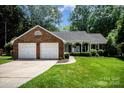 Charming brick home featuring a well-manicured lawn, attached garage, and cozy front porch at 1014 Covewood Ct, Charlotte, NC 28270