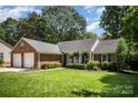 Charming brick home featuring a well-manicured lawn, attached garage, and cozy front porch at 1014 Covewood Ct, Charlotte, NC 28270