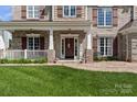 Inviting front porch with brick walkway and detailed trim offers a cozy entrance at 1016 Spanish Moss Rd, Indian Trail, NC 28079
