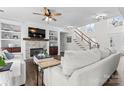 Bright living room with fireplace, built-in shelving, hardwood floors, and a staircase at 1016 Spanish Moss Rd, Indian Trail, NC 28079