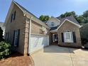 Beautiful brick home showcasing a two-car garage, basketball hoop, and well-maintained lawn at 1043 Cambrook Ct, Concord, NC 28027