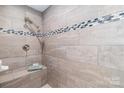 Luxurious tiled shower featuring a built-in bench and decorative mosaic accents at 10743 Ola Dr, Fort Mill, SC 29707