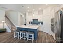 Open-concept kitchen features a large center island, white cabinetry, and hardwood floors, seamlessly connecting to the living spaces at 1133 Idyllic Ln, Waxhaw, NC 28173