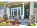 Close up of a charming front porch with cozy wicker chairs, and stone pillars at 1133 Idyllic Ln, Waxhaw, NC 28173