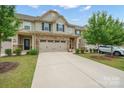 Beautiful exterior of townhome with stone accents, a spacious driveway, and well-maintained landscaping at 117 Lanyard Dr # E, Mooresville, NC 28117