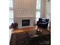 Cozy living room featuring a fireplace, large windows, and comfortable seating with natural light at 1253 Iverleigh Trl, Charlotte, NC 28270