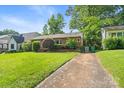 Lovely single-story brick home with mature trees and a spacious front yard at 1315 Cortland E Rd, Charlotte, NC 28209