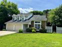 Charming home featuring a two-car garage and landscaped front yard at 14211 Harlequin Dr, Charlotte, NC 28273