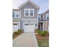 Beautiful townhome featuring a gray exterior, attached garage, and meticulously maintained landscaping at 14806 Tamarack Dr, Charlotte, NC 28278