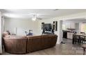 Open concept living room with hardwood floors, ceiling fan, kitchen, and mounted TV at 1518 Glenbar Ct, Clover, SC 29710
