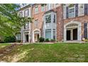Brick townhome exterior featuring a bay window, shutters, and well-maintained lawn at 1530 S Church St # K, Charlotte, NC 28203