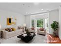 Staged living room showcasing a large bay window, hardwood floors, and contemporary furnishings at 1530 S Church St # K, Charlotte, NC 28203