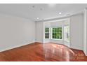 Bright living room with hardwood floors, bay windows, and neutral paint at 1530 S Church St # K, Charlotte, NC 28203