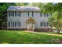 Well-maintained two-story house with a cozy front porch, surrounded by a lush green yard at 1575 Lewis Farm Rd, Kings Mountain, NC 28086
