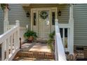 Inviting front porch with decorative wreath, plants, and charming 'Home' welcome sign at 1575 Lewis Farm Rd, Kings Mountain, NC 28086