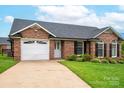 Beautiful brick home boasts a manicured lawn, driveway, and attached two-car garage at 1909 Wexford Ct, Gastonia, NC 28054