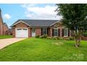 Beautiful brick home boasts a manicured lawn and attached two-car garage at 1909 Wexford Ct, Gastonia, NC 28054