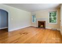 Cozy living room with hardwood floors, a fireplace, and bright windows offering natural light at 204 Blanche Ave, Belmont, NC 28012