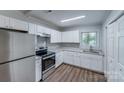 Clean kitchen with white cabinets, stainless steel appliances, granite countertops, and hardwood floors at 2214 Grimes St, Charlotte, NC 28206