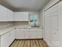 Bright kitchen features white cabinets, neutral countertops, and a stainless steel sink beneath a window at 2214 Grimes St, Charlotte, NC 28206