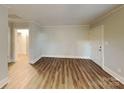 Bright living room features neutral walls and light, wood-look flooring, with entryways to other rooms in the home at 2214 Grimes St, Charlotte, NC 28206