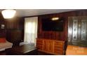 Cozy living room featuring wood-paneled walls, hardwood floors, and built-in cabinetry at 229 W Park Ave, Mooresville, NC 28115