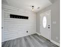 A modern entryway features shiplap walls, a coat rack, and stylish gray laminate flooring at 2706 Stagbuck Dr, Gastonia, NC 28052