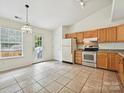 Eat-in kitchen features tile floors, wood cabinets, stainless steel appliances, and an adjacent door to the deck at 2927 Dubberly Ct, Matthews, NC 28105