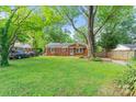 Spacious front yard showcasing a charming brick home with ample parking and lush greenery at 2953 Enfield Rd, Charlotte, NC 28205
