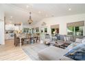 Open-concept living and dining area featuring hardwood floors, white walls, a decorative chandelier and large windows at 307 Lake Head Rd, Norwood, NC 28128