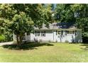 Inviting single-story home featuring a well-manicured lawn and mature tree in the front yard at 3331 Eastwood Dr, Charlotte, NC 28205